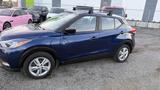 A blue 2019 Nissan Kicks with a roof rack parked on gravel