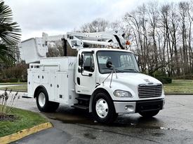 A white 2005 Freightliner M2 106 bucket truck with an extended arm and a tool storage compartment on the side