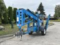 A 2016 Genie TZ-34/20 articulated boom lift in blue with a platform and wheels visible from the rear showing controls and safety labels