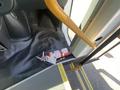 A red fire extinguisher is positioned at the entrance of a vehicle with the door open showcasing a rubberized floor mat