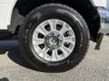 Close-up of a chrome wheel from a 2021 Ford F-250 SD featuring a Goodyear Wrangler tire with a rugged tread design and five-spoke alloy rim