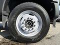 Close-up of a 2022 Ford F600 wheel featuring a white rim and black tire with visible tread patterns and lug nut design