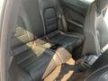 Interior view of a 2013 Mercedes-Benz C-Class rear seating area featuring black leather seats with a center armrest and cup holders