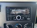 A Kenwood car audio system displaying the time and date with buttons and knobs for tuning and volume adjustments
