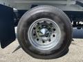 Close-up of a shiny chrome wheel rim with a Double Coin tire on a 2014 Freightliner M2 106 truck