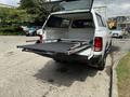 A white 2013 RAM 1500 with an open tailgate displaying a retractable truck bed slide system