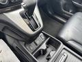 Interior view of a 2014 Honda CR-V gear shift lever with a leather seat and control buttons on the center console