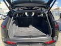 The rear of a 2023 Fisker Ocean with the hatch open showing a spacious trunk area with no visible items inside