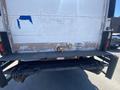 A 2014 International TerraStar box truck with a partially damaged white rear panel and a visible latch mechanism on the back door