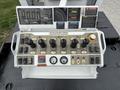 A control panel featuring various levers and gauges used for operating a 2013 Freightliner 114SD truck with warning labels and operational instructions