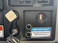 Interior dashboard of a 2012 International DuraStar 4300 showing gauges buttons and warning labels including a filter minder indicator and a key slot
