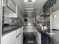 Interior of a 2020 Freightliner MT45 with stainless steel countertops cabinets and ventilation fans along the ceiling