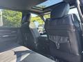 Interior view of a 2018 RAM 3500 showing black leather seats in the back with a panoramic sunroof and the front dashboard partially visible