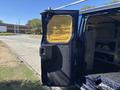 A blue 2016 Ford Transit 150 with an open rear door revealing yellow insulation material inside the cargo area