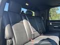 Interior view of the back seat of a 2018 RAM 3500 featuring black leather upholstery with ample seating and safety belts