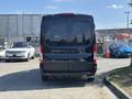Black 2025 Ford Transit T-350 viewed from the rear with a smooth tailgate and rear lights clearly visible