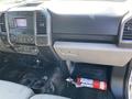 The interior of a 2018 Ford F-150 showing the dashboard control panel and a fire extinguisher placed on the floor near the driver's seat