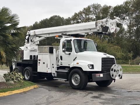 A white 2013 Freightliner 114SD bucket truck with a lift arm and equipment storage compartments on the side