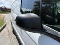 A 2021 Ford Transit Connect with a close-up of the side mirror highlighting its black casing and reflective surface