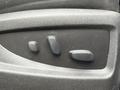 A control panel with three buttons for adjusting car seat positions on a black textured surface