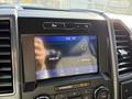 A close-up view of the dashboard display of a 2021 Ford F-250 SD showing the time temperature and audio settings