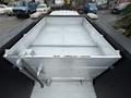 A metallic flatbed with an empty rectangular tub structure on the back of a 2016 Ford F-550 Super Duty truck