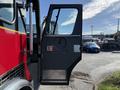 The open door of a 1992 Emergency One Typhoon Superior fire truck showing a black interior with a circular handle and window glass