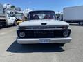 A 1962 Ford 2WHDR truck with a classic design featuring a white exterior and a distinctive front grille with a black emblem