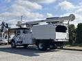 A 2019 Freightliner M2 106 utility truck with a white body a large boom lift on the top and a storage compartment at the back