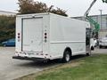 A white 2012 Ford E-450 Super Duty box truck with a roll-up rear door and red taillights