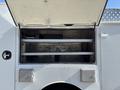 A 2011 Ford F-550 with an open compartment revealing shelves inside and storage boxes