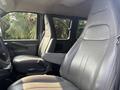 A 2021 Chevrolet Express interior featuring two front seats with a leather finish and adjustable armrest