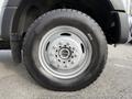 A close-up view of a silver wheel on a 2020 Ford F-550 featuring a black tire and lug nut details