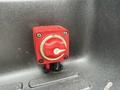 A close-up of a red battery disconnect switch with a knob labeled on and off