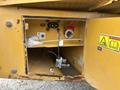 Close-up of a service panel on a 2012 Caterpillar 980 showing electrical connections and a compartment with a valve and wiring