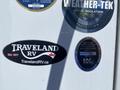 A 2021 Grand Design Recreational ST3478MBS with various branded stickers including Traveland RV and certifications for insulation and manufacturing compliance
