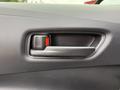 Interior door handle of a 2025 Toyota Corolla featuring a sleek design and a red indicator