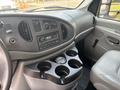 Interior view of a 2008 Ford Econoline dashboard featuring a radio control panel and a cup holder console with space for four cups