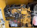 2022 Caterpillar 306 engine with various connected hoses wires and components including a cylindrical canister and a red fluid reservoir