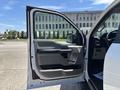 A 2019 Ford F-150 with the driver's side door open showing the interior features including the armrest and door handle