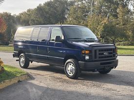 A blue 2013 Ford E-350 Super Duty van parked with a sleek exterior and large wheels