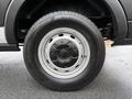 A close-up of the wheel of a 2022 Ford Transit showcasing a silver wheel rim and all-season black tire with visible tread pattern