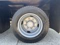 Close-up of a tire and wheel on a 2005 GMC C7500 Topkick featuring a silver rim with multiple bolts and a rugged black tire