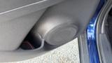 A round car speaker located on the interior door panel of a 2019 Nissan Kicks