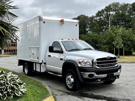 A 2008 Sterling Bullet with a white box truck body and orange roof lights is parked at an angle displaying its front and side features