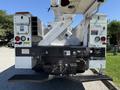 A 2013 International 7400 truck with a flatbed and a mounted aerial lift equipment clearly visible in the foreground