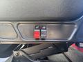 Close-up of two buttons on the side of a car seat one red and one black for adjusting seat position