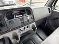 Interior dashboard of a 2021 Freightliner M2 106 featuring controls for audio climate and various vehicle functions along with a central screen and gauges