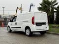 A white 2017 RAM ProMaster City van is parked with sliding side doors and a rear cargo area visible