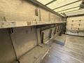 Interior view of a 2012 Ford Econoline with metal shelves and benches installed along the walls of the cargo area